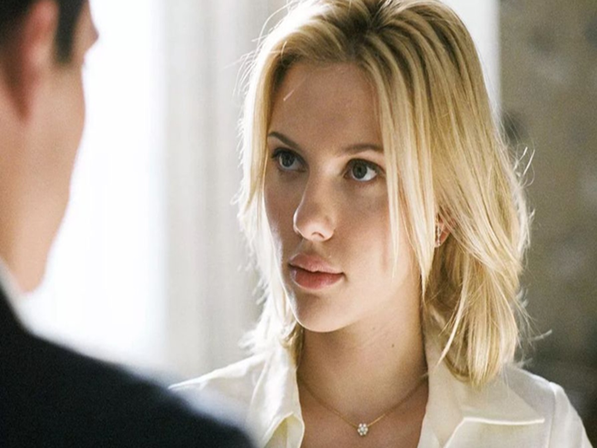 Scarlett Johansson posing confidently at a film premiere, wearing a glamorous outfit and smiling for cameras