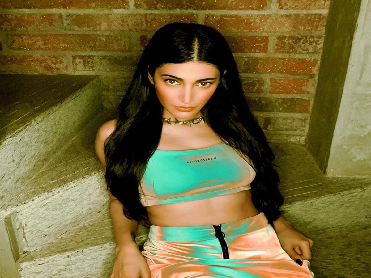 Shruti Haasan poses confidently in a metallic crop top and skirt outfit.
