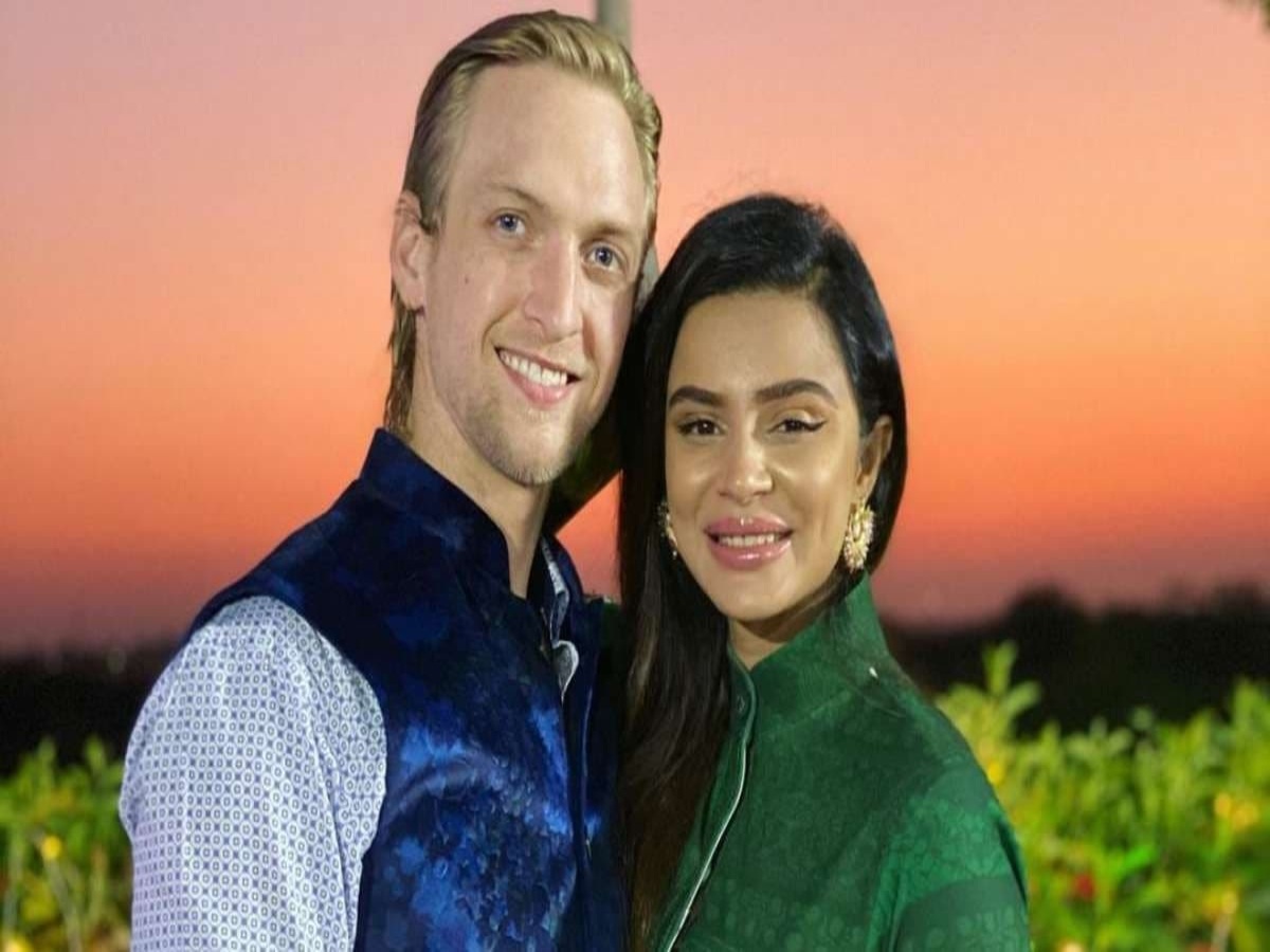 Aashka Goradia kissing fiancé Brent Globe at the Eiffel Tower, embodying their love and excitement before their December wedding.