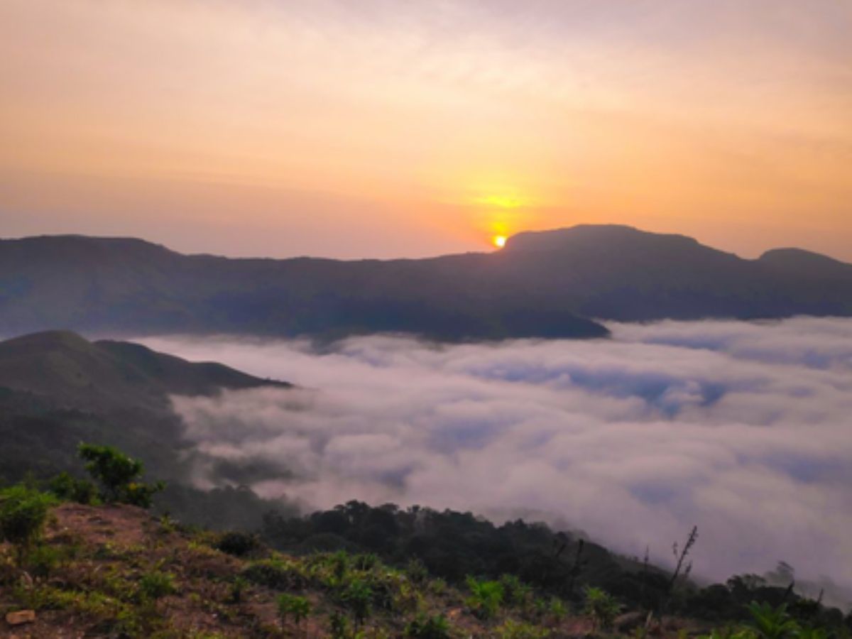 “Sunrise over mist‑blanketed Western Ghats from Mandalpatti Peak.