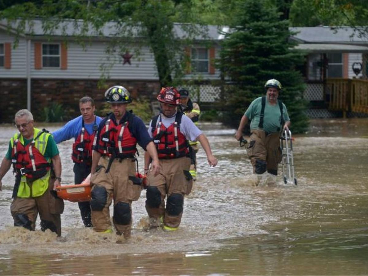Two girls watching Texas flood while standing by the riverbank.