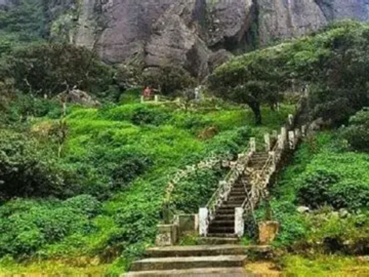 Rocky summit of Kote Betta hill with trekkers at dawn in Coorg