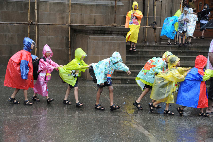 Schoolchildren walking through floodwater in Delhi