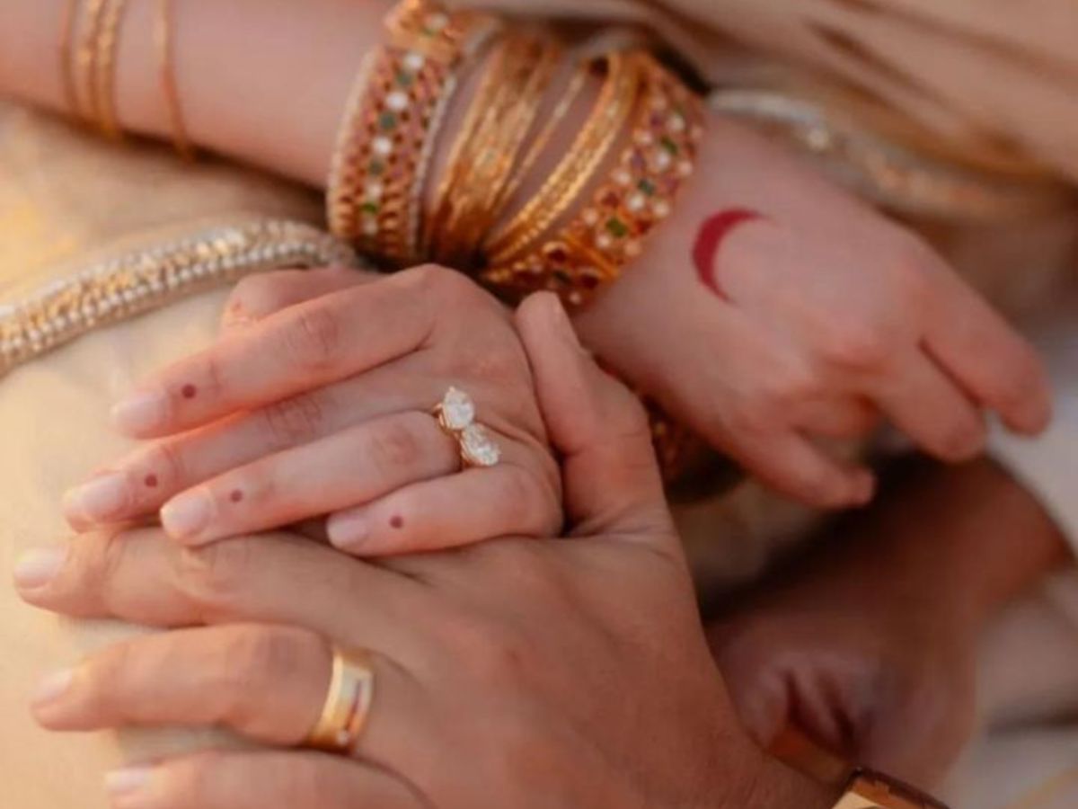 Aditi Rao Hydari’s wedding hand adorned with simple dot mehndi and a crescent moon on the palm, layered with traditional bangles and a diamond ring.