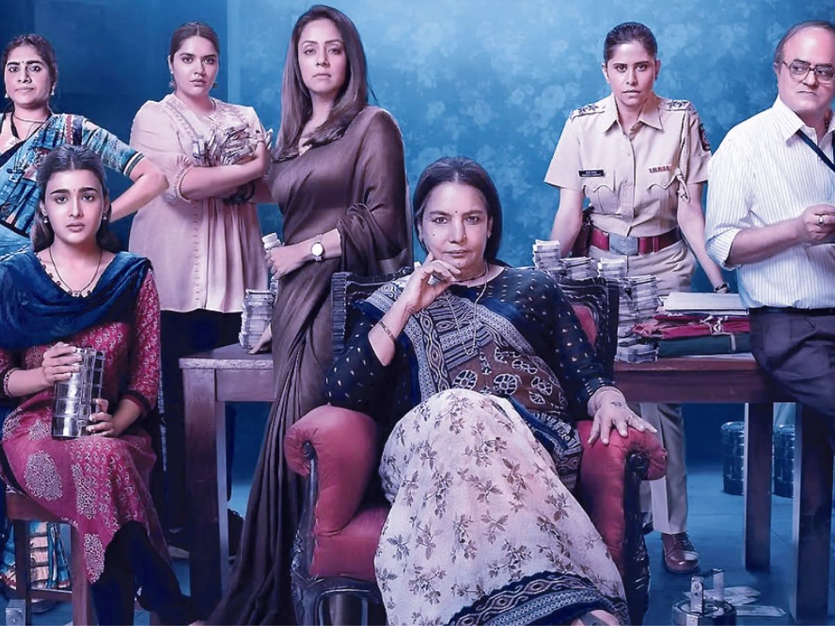 Ensemble cast of Dabba Cartel with tiffin boxes and cash, led by veteran actress Shabana Azmi.