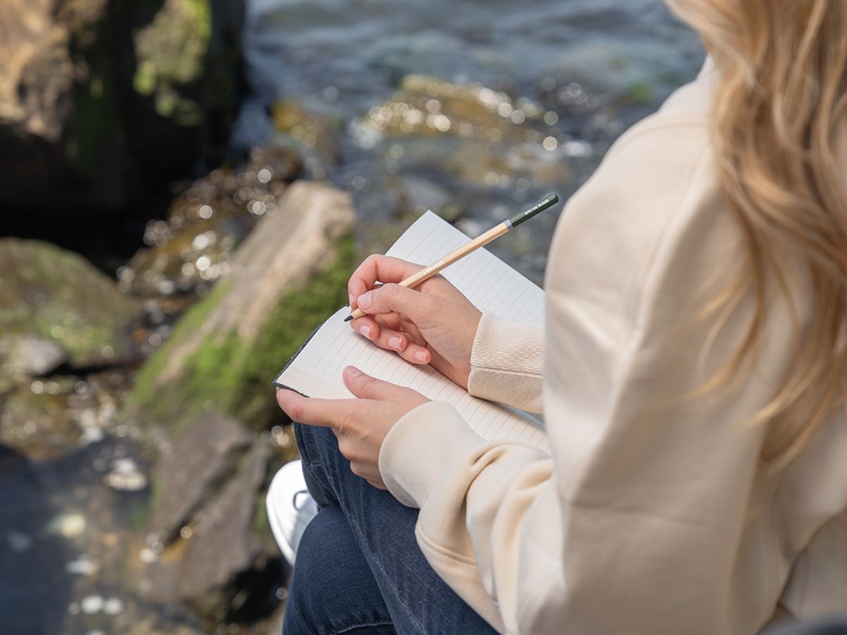 Hand writing in a diary with a calm surrounding