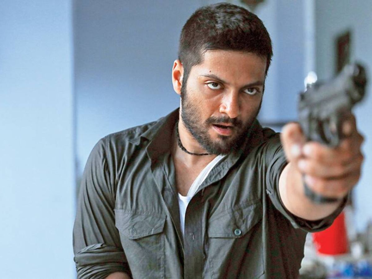 Ali Fazal as Guddu Pandit holding a gun, looking intense