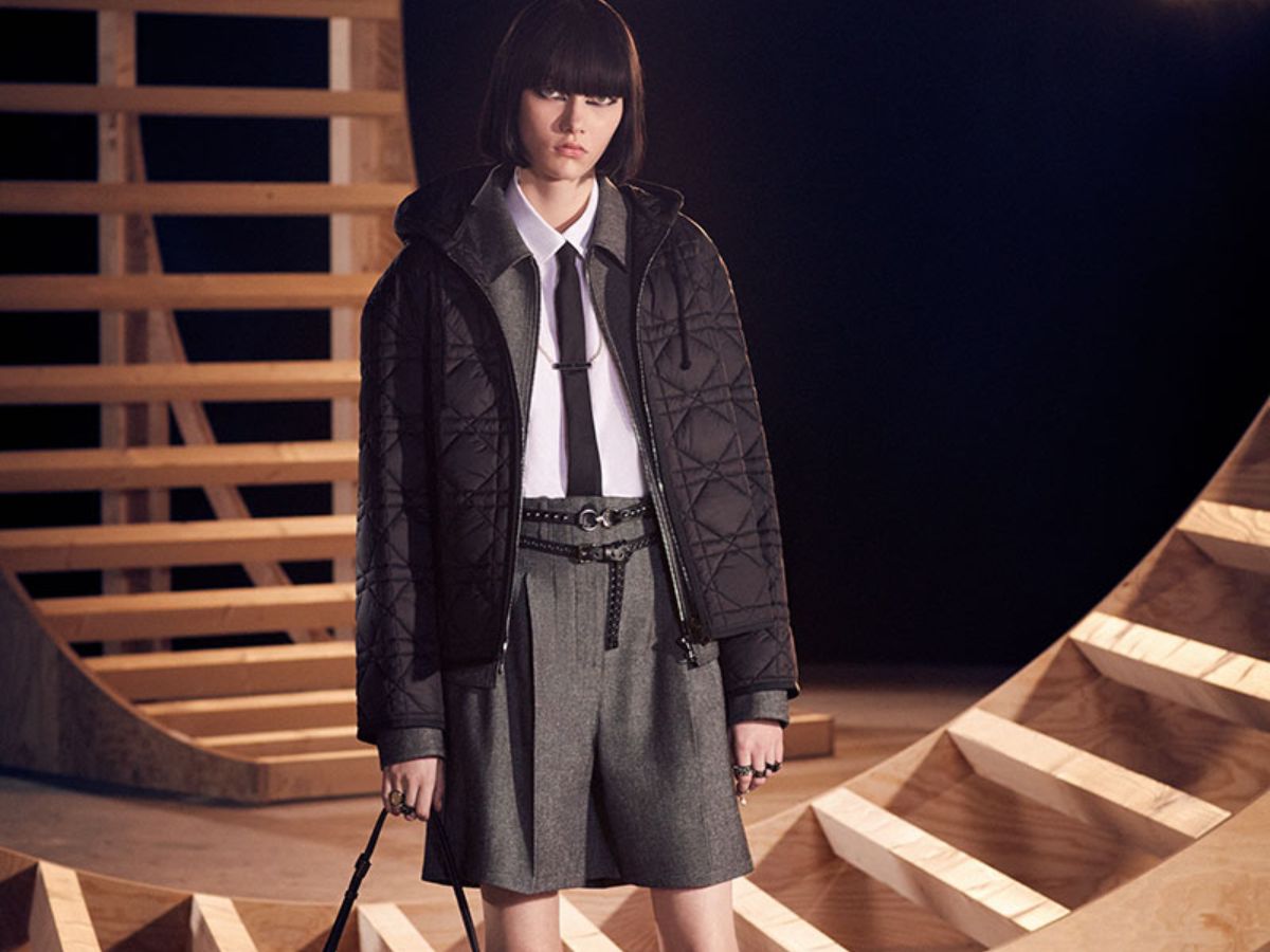 Woman in a pleated Dior skirt and structured jacket