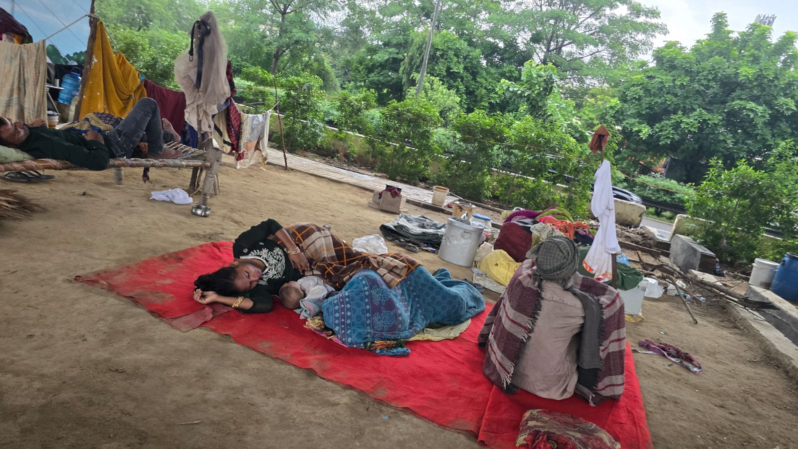 Residents lying on the ground at Yamuna flood relief camp.