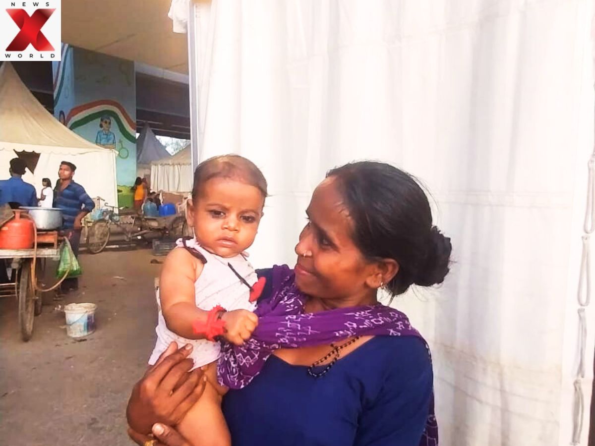 Hope in her arms: A mother clings to resilience inside the Yamuna flood relief camp.