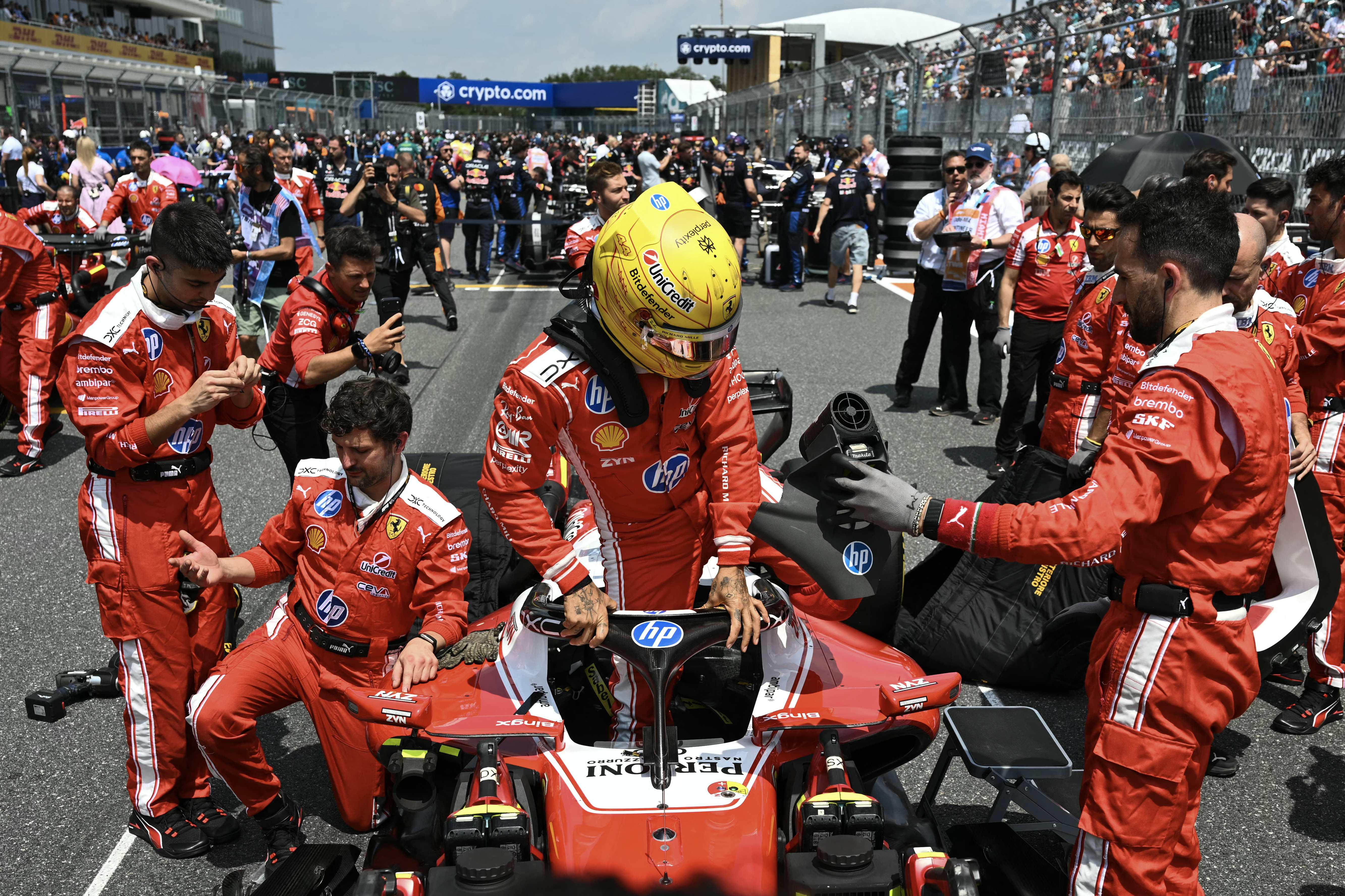 Ferrari's British driver Lewis Hamilton gets into his car at the starting grid before the start of the 2026 Miami Formula One Sprint at Miami International Autodrome in Miami Gardens, Florida, on May 2, 2026. (Photo by CHANDAN KHANNA / AFP)